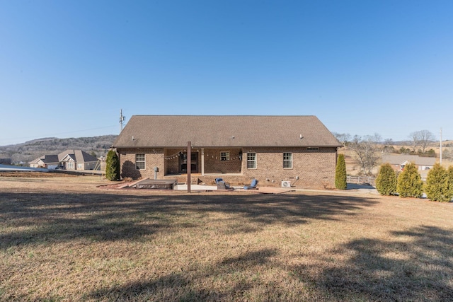 back of property with a yard and a patio