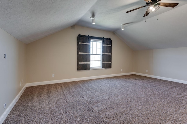 bonus room with ceiling fan, vaulted ceiling, a textured ceiling, and carpet