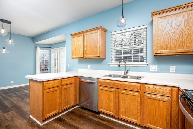 kitchen featuring appliances with stainless steel finishes, decorative light fixtures, dark wood-type flooring, sink, and kitchen peninsula