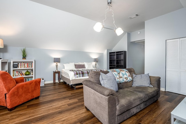 bedroom with dark wood-type flooring, a closet, and vaulted ceiling