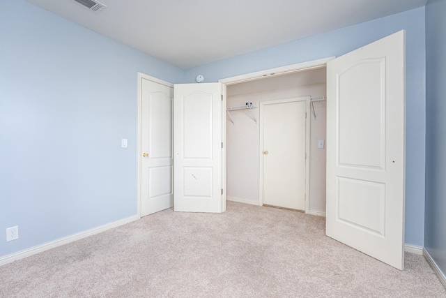 unfurnished bedroom featuring a closet and light carpet