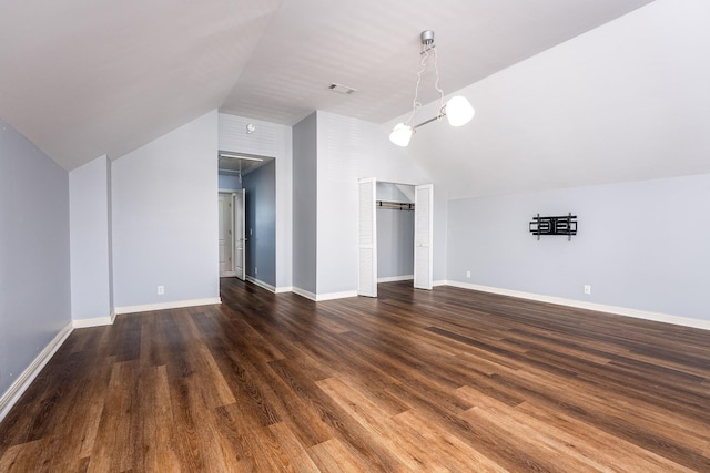 unfurnished living room with dark wood-type flooring and vaulted ceiling