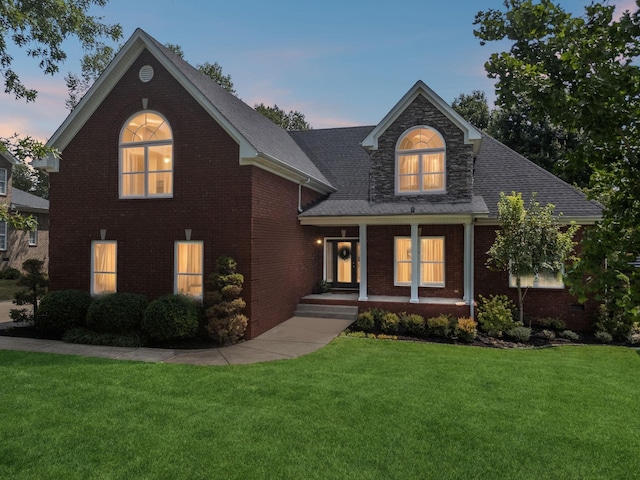 view of front of property with covered porch and a yard