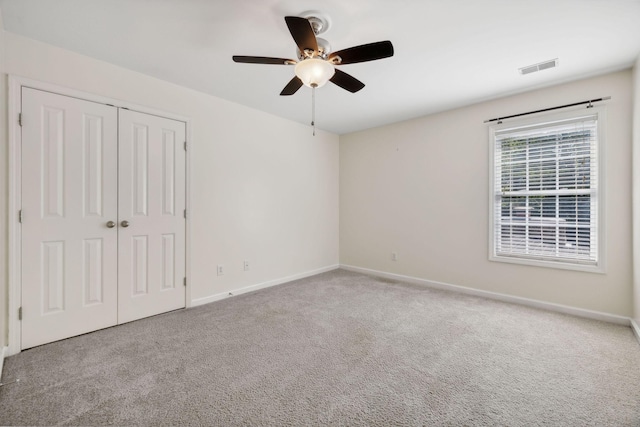 unfurnished bedroom with ceiling fan, a closet, and light carpet