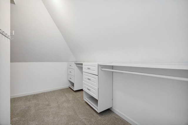 walk in closet featuring light carpet and vaulted ceiling