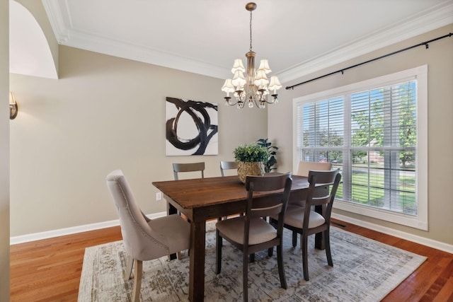 dining area featuring crown molding, hardwood / wood-style floors, and a notable chandelier