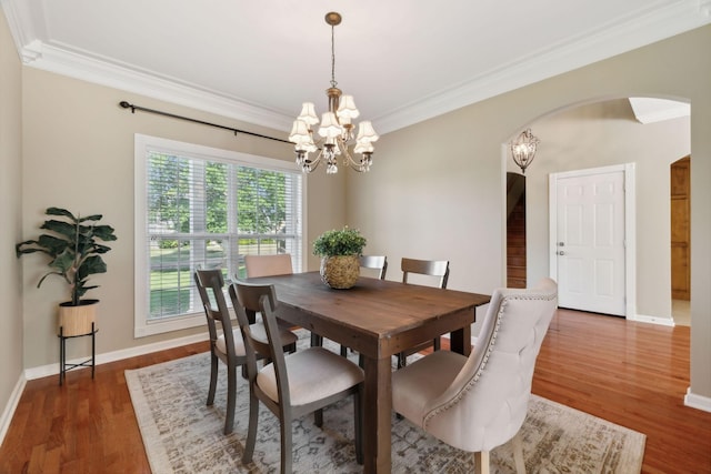 dining space with a chandelier, ornamental molding, and dark hardwood / wood-style flooring