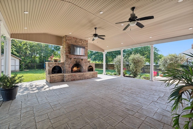 view of patio / terrace featuring ceiling fan and an outdoor stone fireplace