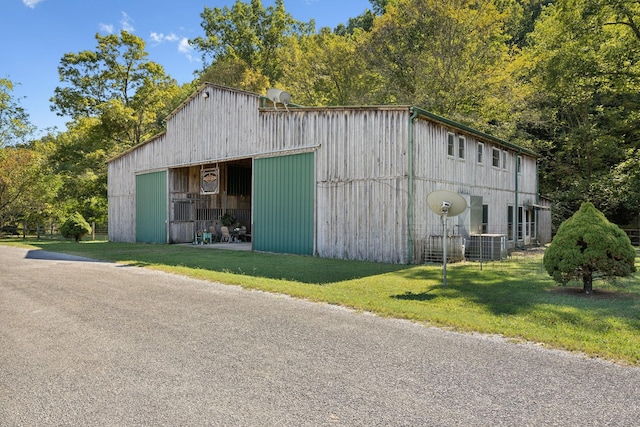 view of outbuilding with central AC unit and a lawn