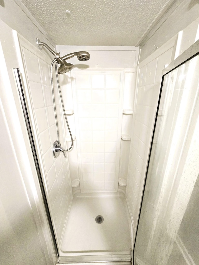 bathroom with a textured ceiling and walk in shower