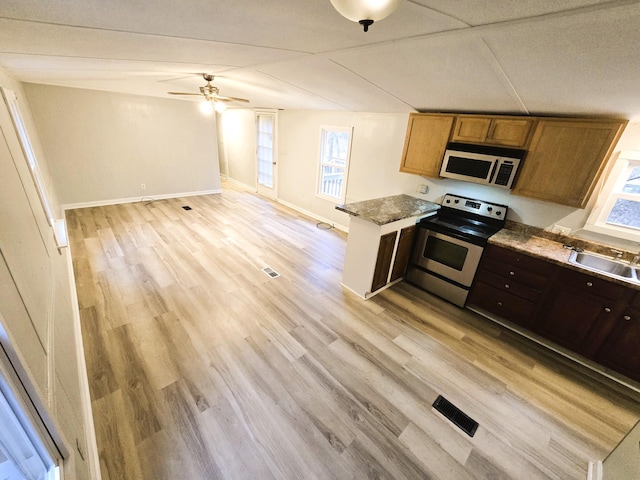 kitchen with appliances with stainless steel finishes, sink, light hardwood / wood-style flooring, kitchen peninsula, and ceiling fan