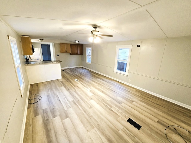 unfurnished living room with ceiling fan, light hardwood / wood-style floors, and lofted ceiling