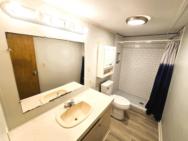 bathroom featuring a textured ceiling, hardwood / wood-style floors, vanity, a shower with curtain, and toilet