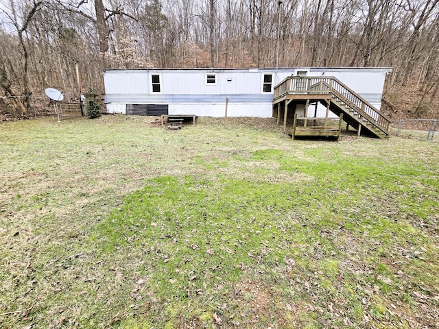 rear view of property with a wooden deck and a lawn