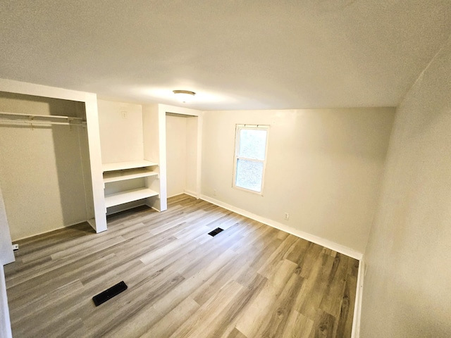 unfurnished bedroom with hardwood / wood-style flooring and a textured ceiling