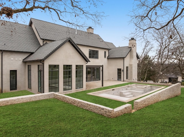 rear view of property with a jacuzzi, a patio area, and a lawn