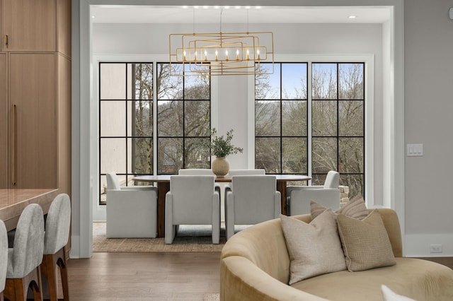 dining space featuring wood-type flooring and an inviting chandelier