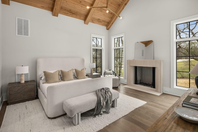 bedroom featuring multiple windows, wooden ceiling, beam ceiling, and light hardwood / wood-style flooring