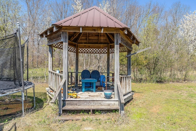 deck featuring a gazebo, a yard, and a trampoline