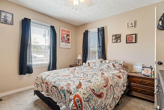 carpeted bedroom featuring ceiling fan, a textured ceiling, and baseboards