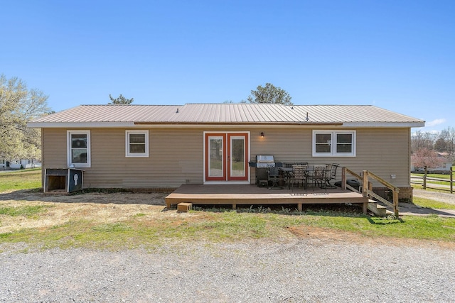 back of property with a deck, french doors, and metal roof