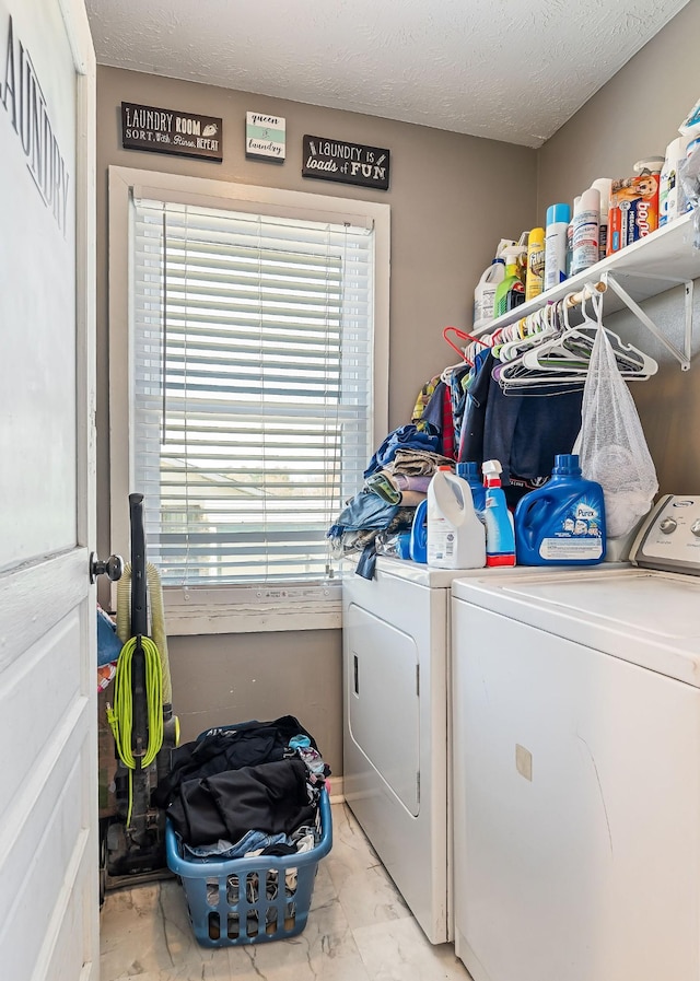 laundry area with a textured ceiling, marble finish floor, laundry area, and washer and clothes dryer