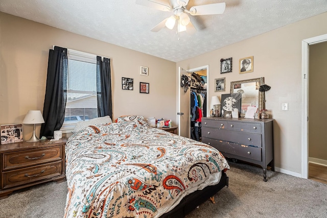 bedroom with baseboards, ceiling fan, a closet, a textured ceiling, and a walk in closet
