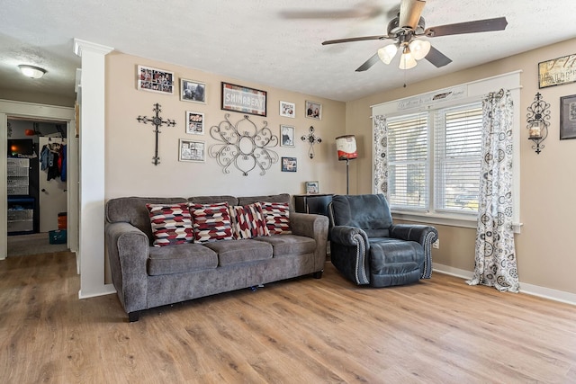 living room featuring a textured ceiling, a ceiling fan, and wood finished floors