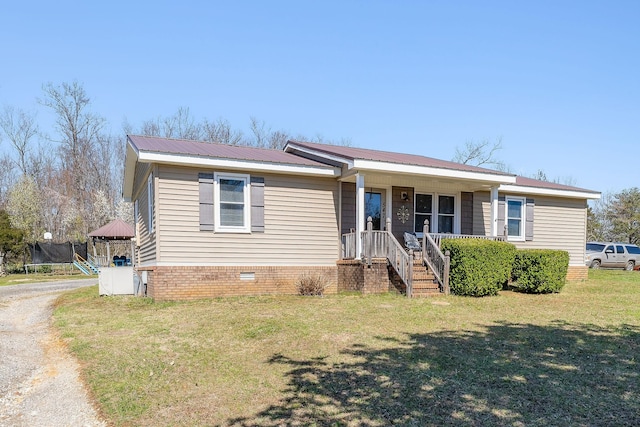 view of front of property with driveway, a trampoline, metal roof, a front yard, and crawl space