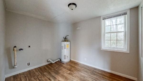 washroom with hardwood / wood-style flooring, electric dryer hookup, and electric water heater