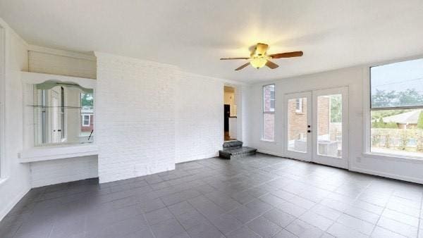 spare room featuring ceiling fan, a wealth of natural light, and french doors