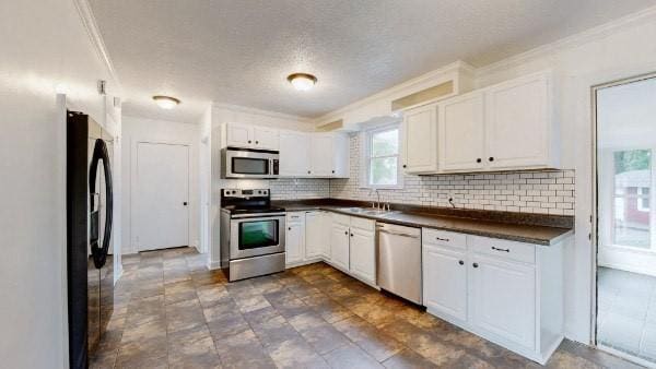 kitchen featuring sink, white cabinetry, decorative backsplash, and appliances with stainless steel finishes