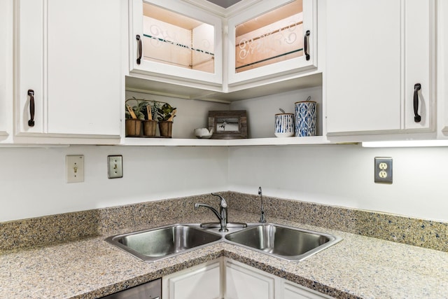 kitchen with sink, white cabinetry, dishwashing machine, and light stone countertops