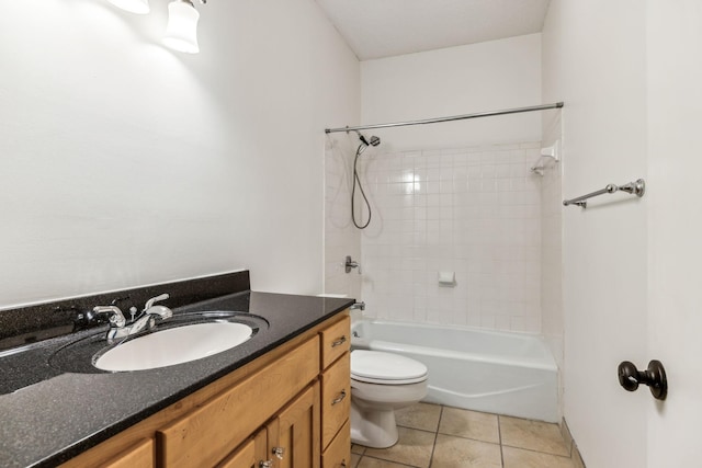 full bathroom with tiled shower / bath, tile patterned floors, vanity, and toilet