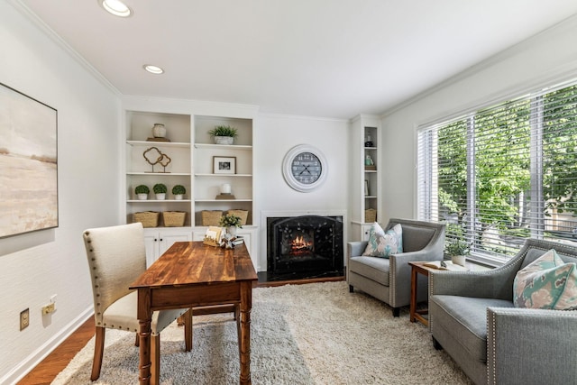 interior space with built in shelves, hardwood / wood-style flooring, and ornamental molding