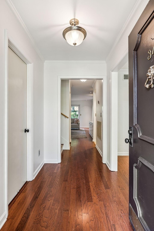 corridor with ornamental molding and dark hardwood / wood-style floors