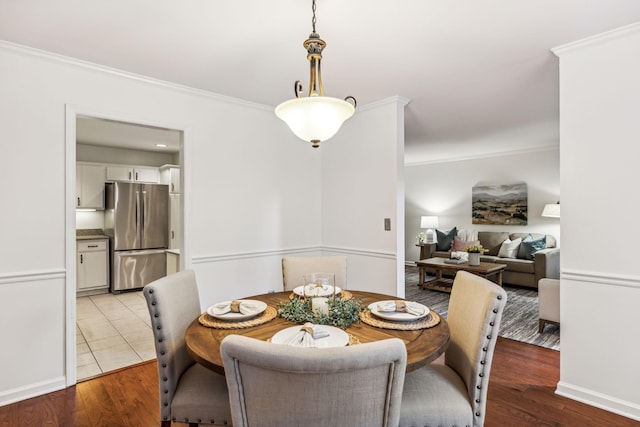 dining room with crown molding and light hardwood / wood-style floors