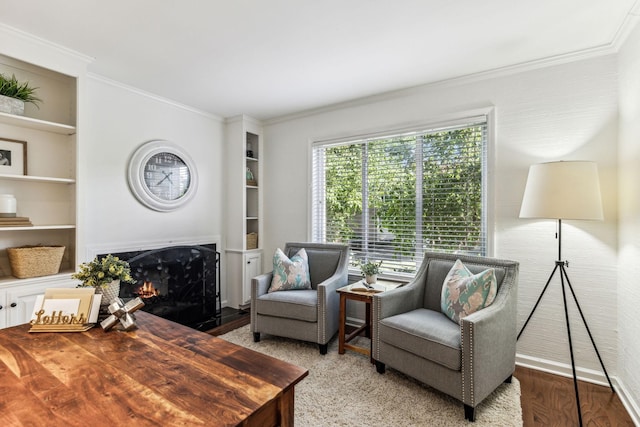 living room with hardwood / wood-style flooring, built in shelves, and crown molding