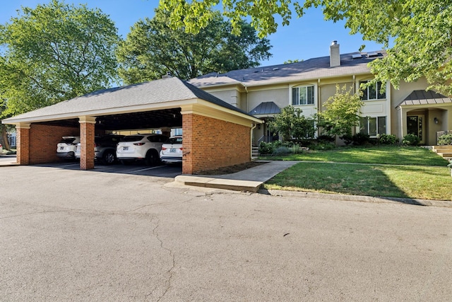 view of front of property with a carport and a front lawn