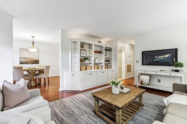 living room with dark hardwood / wood-style floors and crown molding