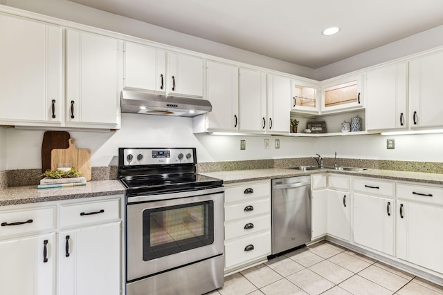 kitchen with sink, white cabinetry, light tile patterned floors, and stainless steel appliances