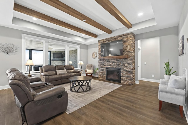 living room with dark wood-type flooring and a stone fireplace