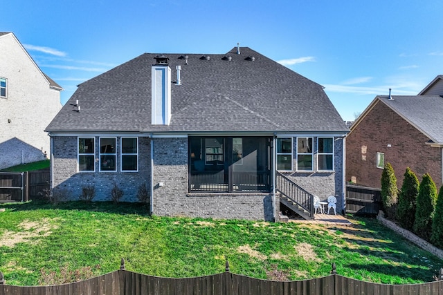 rear view of property with a yard and a sunroom