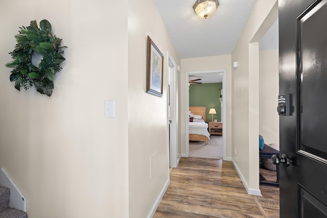 corridor featuring wood-type flooring and a textured ceiling