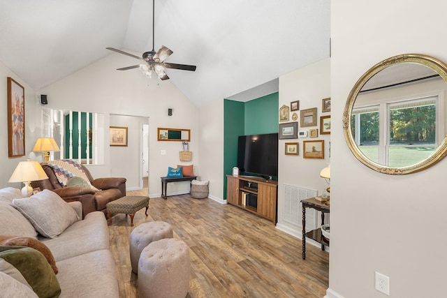 living room featuring light hardwood / wood-style floors, ceiling fan, and vaulted ceiling