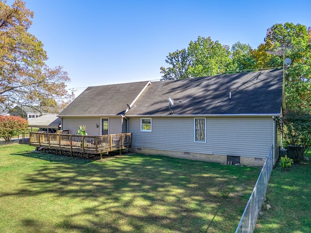 rear view of house with a wooden deck and a lawn