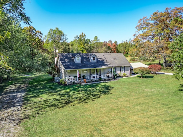 back of property with covered porch and a yard