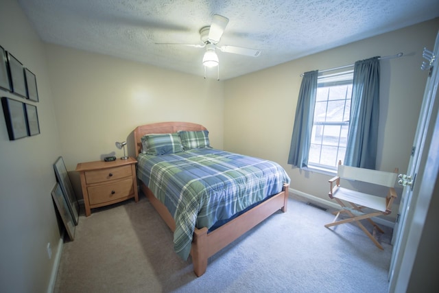 bedroom featuring ceiling fan, a textured ceiling, and light carpet