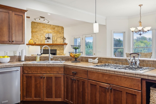 kitchen featuring vaulted ceiling, hanging light fixtures, appliances with stainless steel finishes, sink, and tile countertops