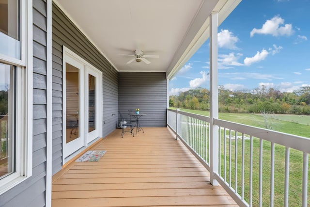 wooden deck with ceiling fan and a yard